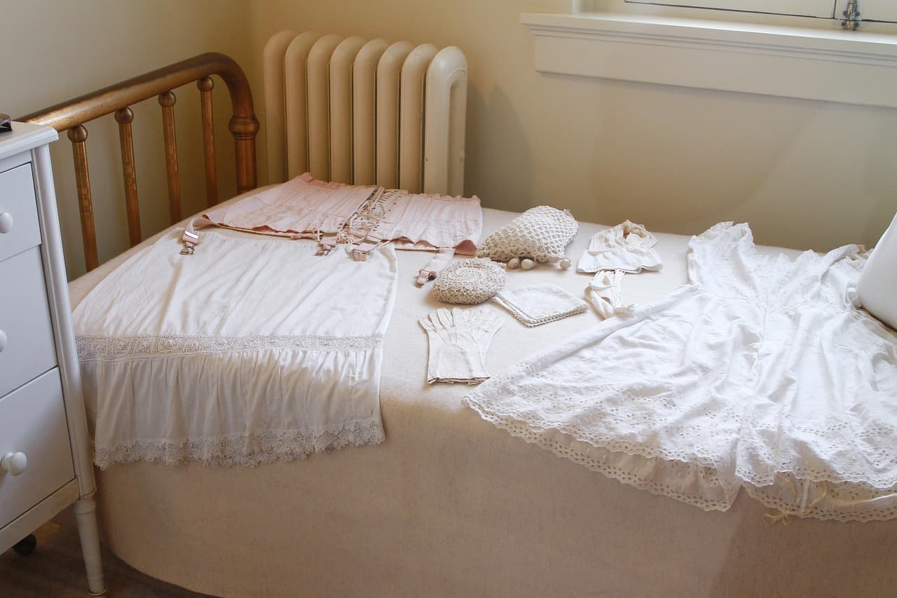 A white column radiator beside a brass bed in a bedroom